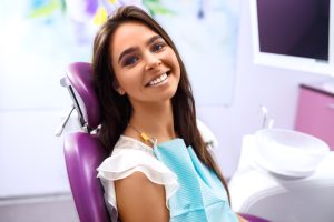 smiling female patient in dental chair